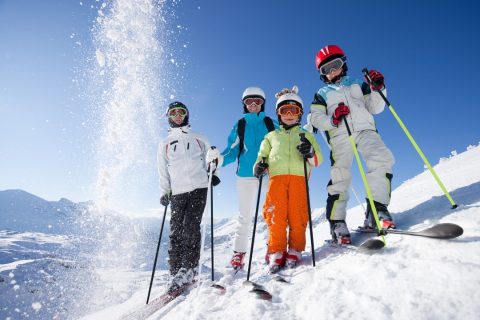 Family in sunshine on a ski slope