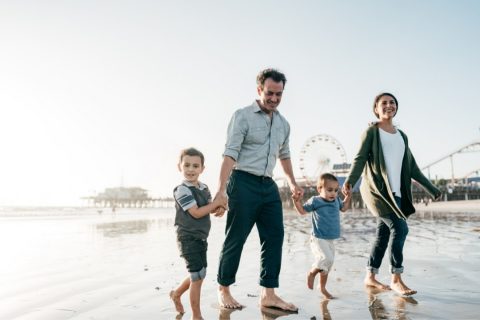 Family walking on beach in california