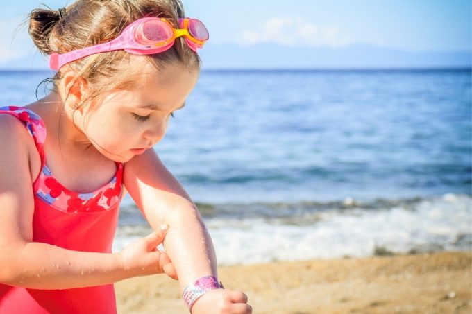 Child looking at pain in their arm - travel health