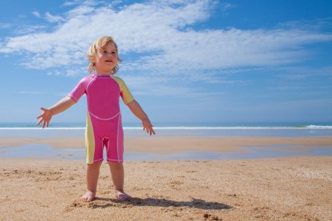 a small child in a pink baby rash guard