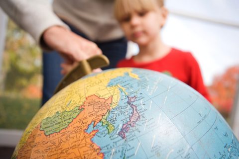 child being shown a picture of the globe