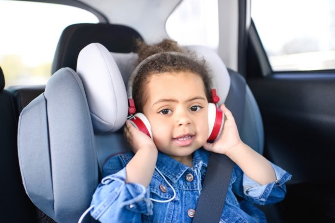 Toddler in a car seat with a set of headphones