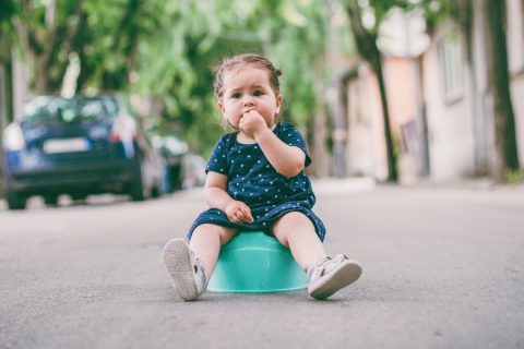 Toddler sitting on potty in the street - travel potty guide