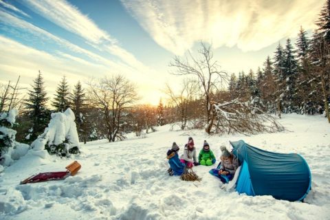 A family camping in a tent in the snow