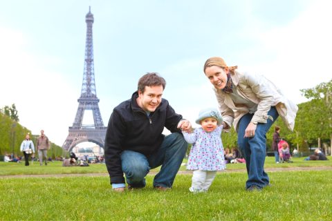 A family with infant in front of the eiffel tower - plan your family trip to France