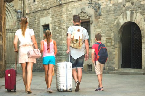 a family with suitcases walking through the streets of an old city