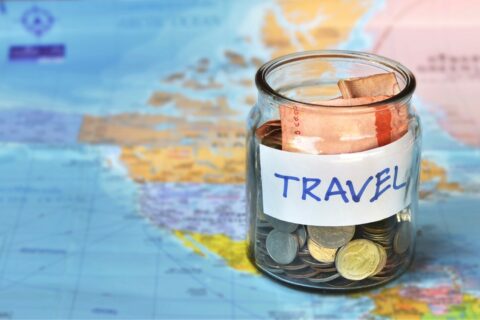 a jar of travel money on a world map