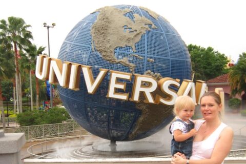 a mum holding a toddler at the entrance to Universal orlando